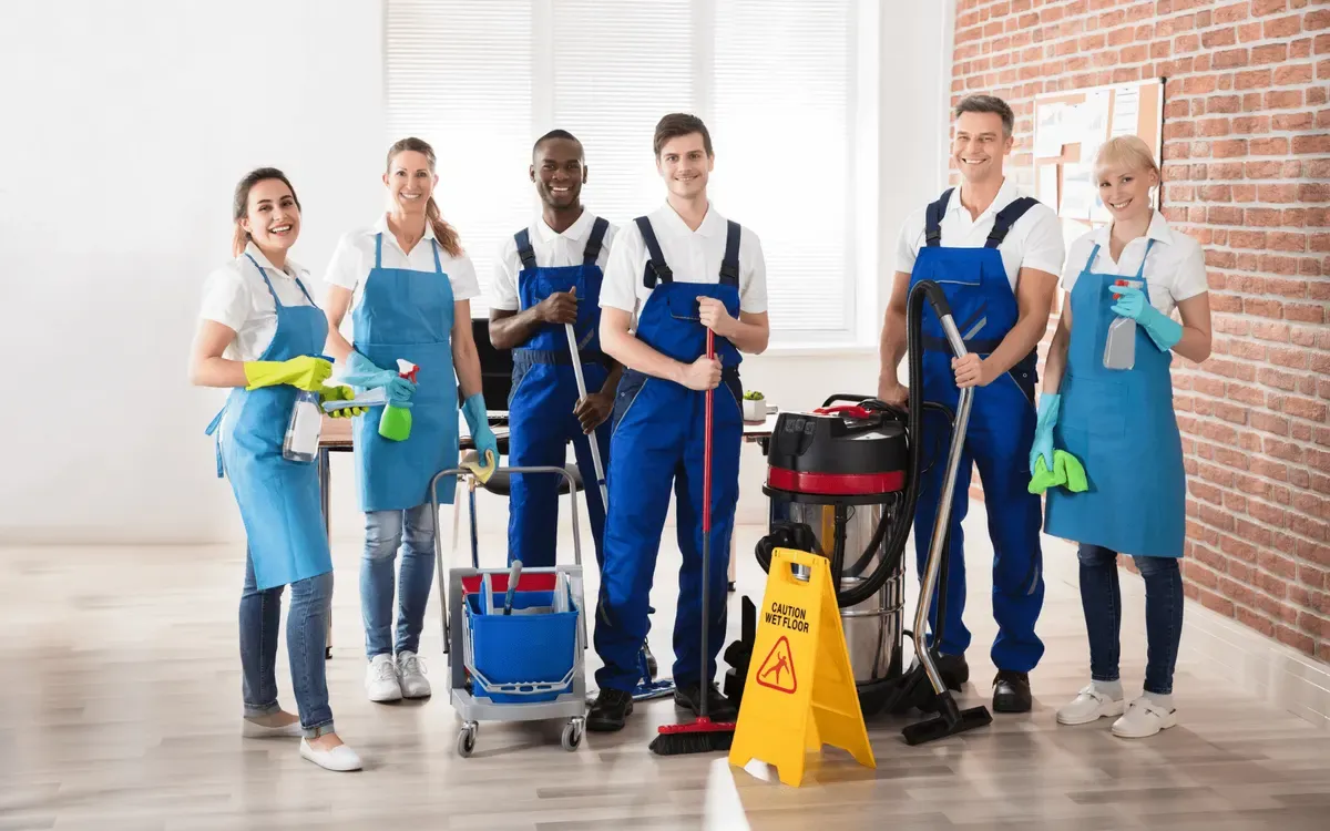 Professional cleaning team with mops, vacuum, and janitorial supplies ready for service.