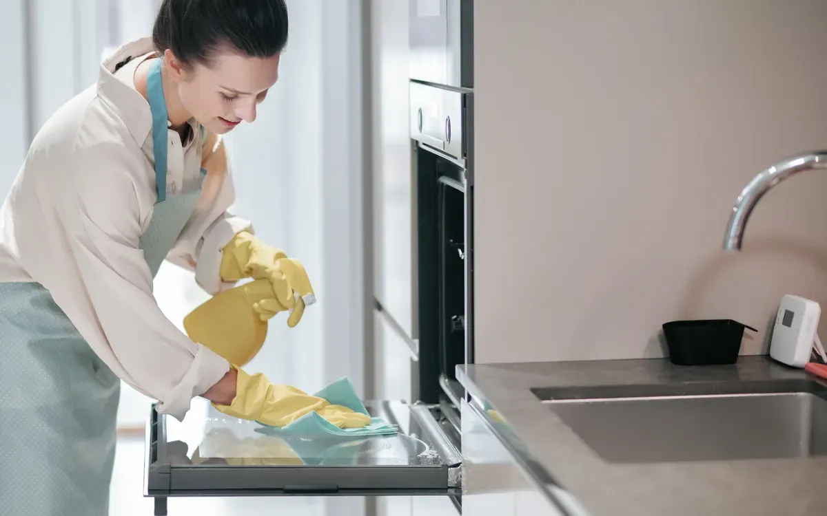 Wiping and sanitizing the oven door and interior.