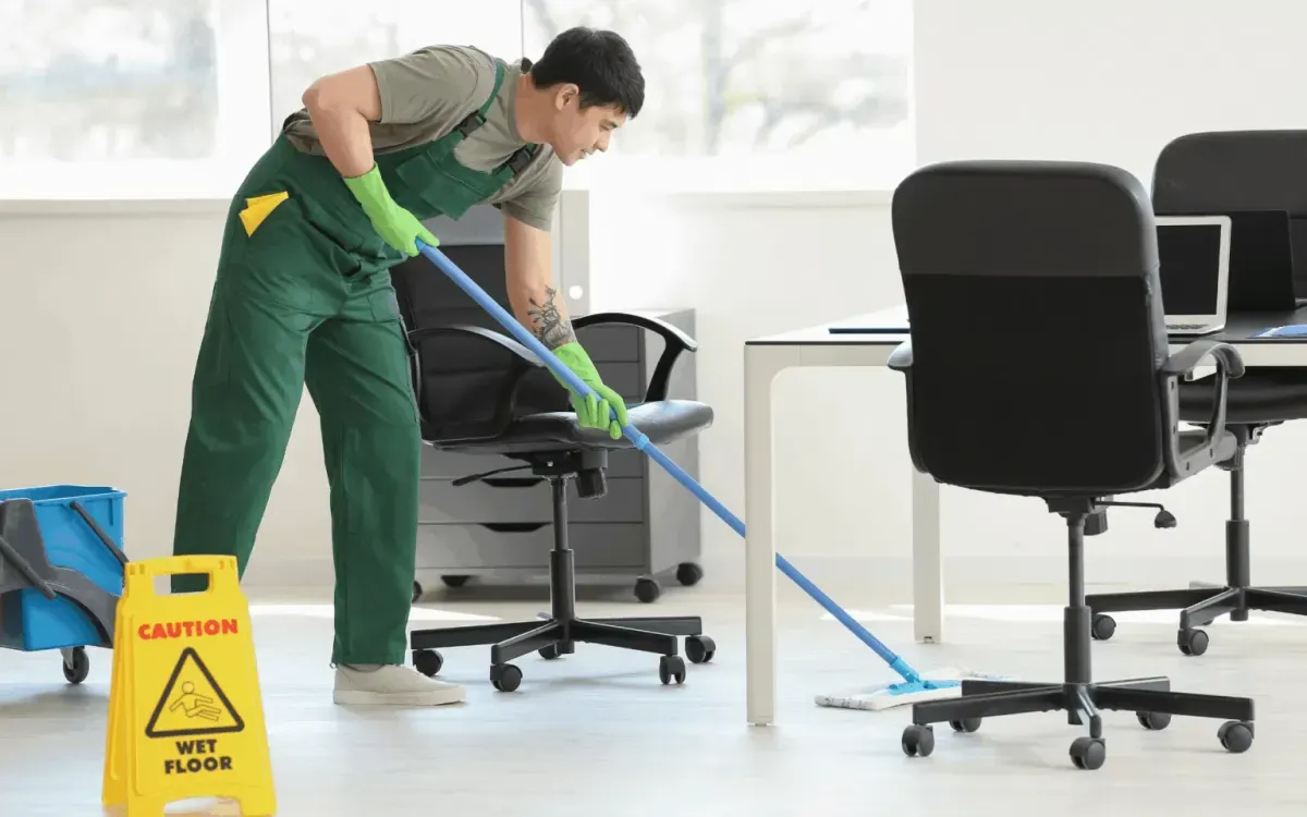 Male and female cleaners in uniforms cleaning sliding glass doors, commercial window cleaning service